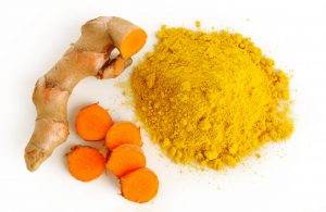 Turmeric root and powder on white background